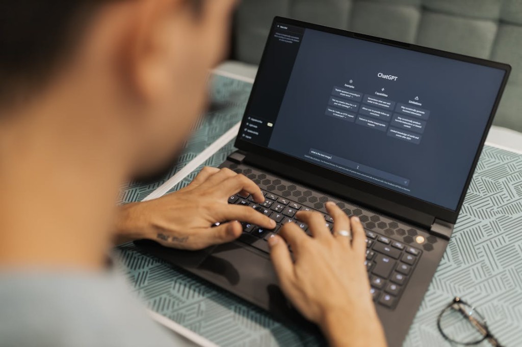 Person typing into ChatGPT on a laptop, representing generative engine optimization and AI search